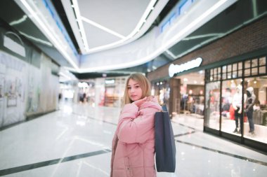 Güzel bir genç kız elinde alışveriş alışveriş merkezi dışarı asılı. Alışveriş merkezine.