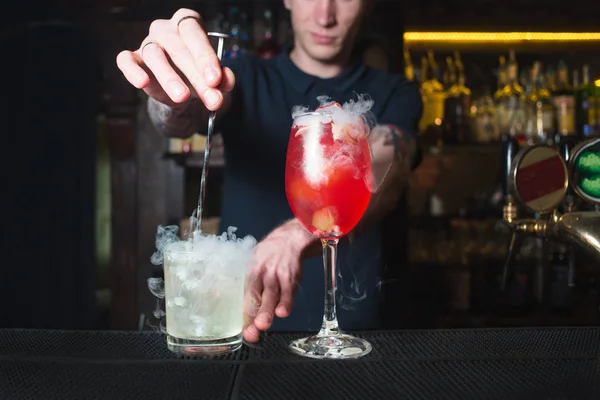 Bartender mencampur alkohol dalam koktail. Membuat minuman beralkohol yang indah di bar . — Stok Foto