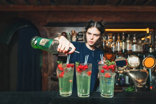 Девушка-бармен делает прекрасный алкогольный фруктовый коктейль. Бармен делает коктейль в пабе . — стоковое фото