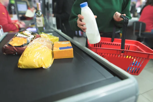 A lány bemutatja a szupermarket pénztári termékek. — Stock Fotó