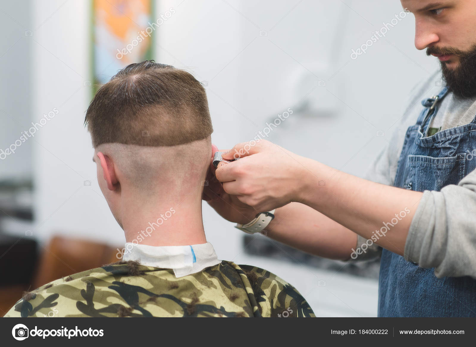 Stylish men's haircut in barbershop. Barber makes a hairstyle for the  client. Barber shaves the neck of the client trimmer Stock Photo by  ©bodnarphoto 184000222