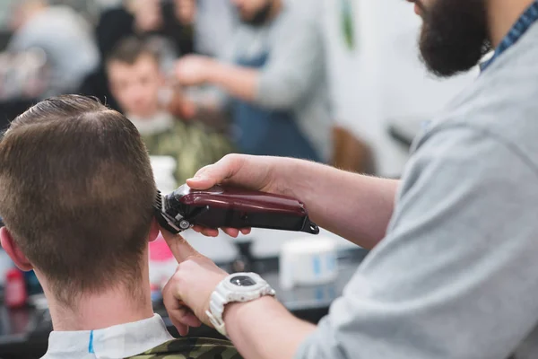 Obtendo corte de cabelo Cabeleireiro. Barbeiro começa a criar um penteado masculino elegante para um penteado. Oração masculina em Maloney da Beleza . — Fotografia de Stock