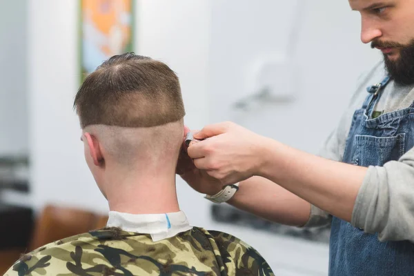 Stilvoller Männerfriseur im Friseursalon. Friseur fertigt Frisur für den Kunden an. Friseur rasiert dem Kundenschneider den Hals — Stockfoto