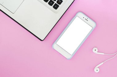 Beyaz bir ekran, bir dizüstü bilgisayar ve pembe bir arka plan üzerinde kulaklık ve metin için bir yer ile bir telefon. Düz yatıyordu Gadget'ı düzen