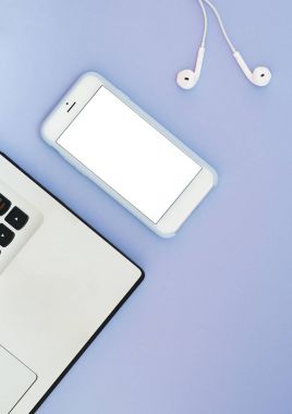 Beyaz bir ekran, bir dizüstü bilgisayar ve mavi bir arka plan üzerinde kulaklık ile bir telefon. Lay becerikli alet düz ve metin için yer.