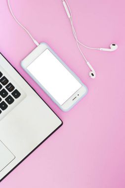 Beyaz bir ekran, bir dizüstü bilgisayar ve pembe bir arka plan üzerinde kulaklık ve metin için bir yer ile bir telefon. Düz yatıyordu Gadget'ı düzen