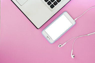 Beyaz bir ekran, bir dizüstü bilgisayar ve pembe bir arka plan üzerinde kulaklık ve metin için bir yer ile bir telefon. Düz yatıyordu Gadget'ı düzen.