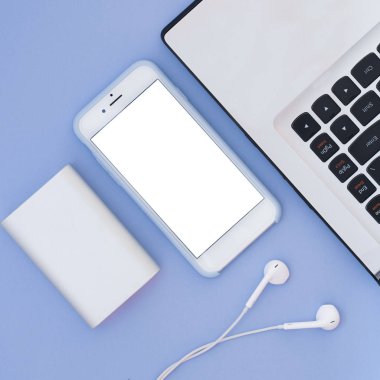 Dizüstü bilgisayar, telefon, kulaklık ve güç üzerinde mavi bir arka plan banka. Düz yatıyordu kompozisyon ve metin için yer. Üstten Görünüm