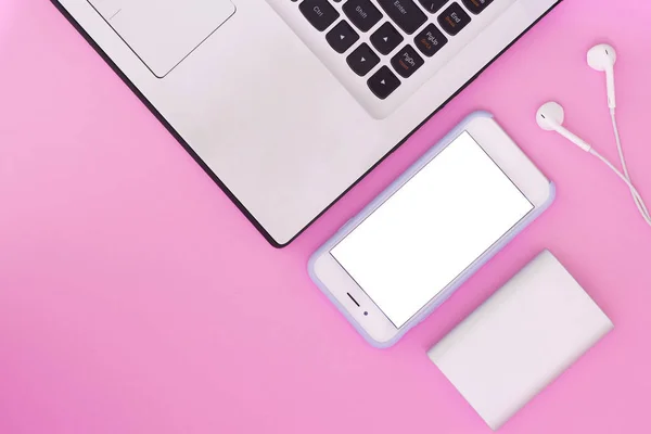 Computer portatile, telefono, cuffie e power bank su sfondo rosa. Lay flat composizione e luogo per il testo. Vista dall'alto . — Foto Stock