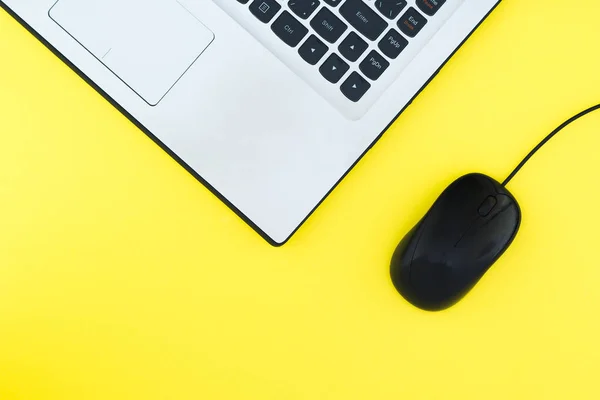 El ratón de la computadora con cable y el portátil están aislados sobre un fondo amarillo. Puesta plana — Foto de Stock