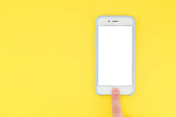 Imagen plana de smartphone y dedo. Una persona con el dedo desbloquea el teléfono inteligente sobre un fondo amarillo. Vista superior — Foto de Stock