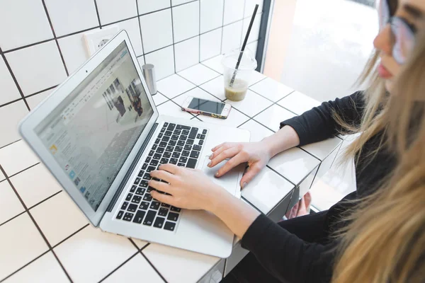 Une blogueuse utilise Internet sur un ordinateur portable dans un café léger élégant. Étudiant étudiant dans un café et boire un smoothie . — Photo