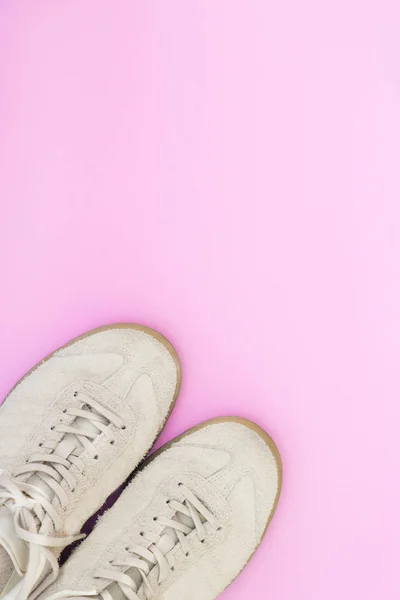 Lys sneakers på en lys lyserød baggrund. Minimalistisk komponi- - Stock-foto
