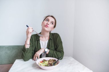 Sevimli genç kız masada yemek yiyen ve tat zevk alır. Bir kadın yeme keyfini