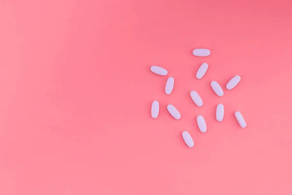 Λευκή κολπική χάπια σε ένα λαμπερό ροζ παστέλ φόντο και μια θέση για το κείμενο. Επίπεδη θέσει — Φωτογραφία Αρχείου