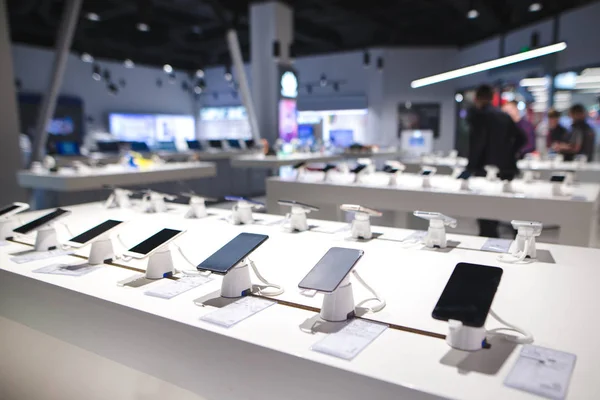 Vitrine avec smartphones dans le magasin d'électronique moderne. Achetez un téléphone portable. De nombreux smartphones sur l'étagère du magasin de technologie — Photo