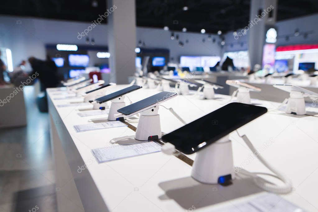 Smartphones on the background of the electronics store. Department of mobile phones in the tech store. A modern gadget store