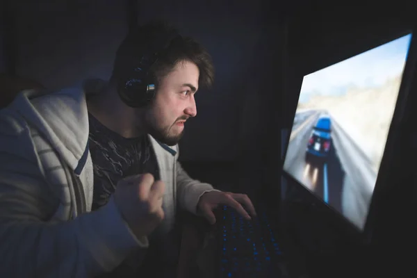 Emotie gamer met baard wedstrijden thuis spelen op een computer. Angry young man spelen op de computer's nachts en boos — Stockfoto