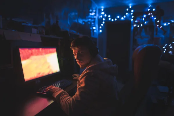 Retrato de um homem que se senta em casa em um quarto acolhedor perto do computador — Fotografia de Stock