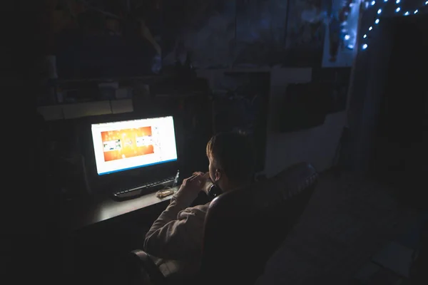 Egy férfi ül este egy számítógép asztal az Internet segítségével. Éjszakai szörfözés az interneten. — Stock Fotó