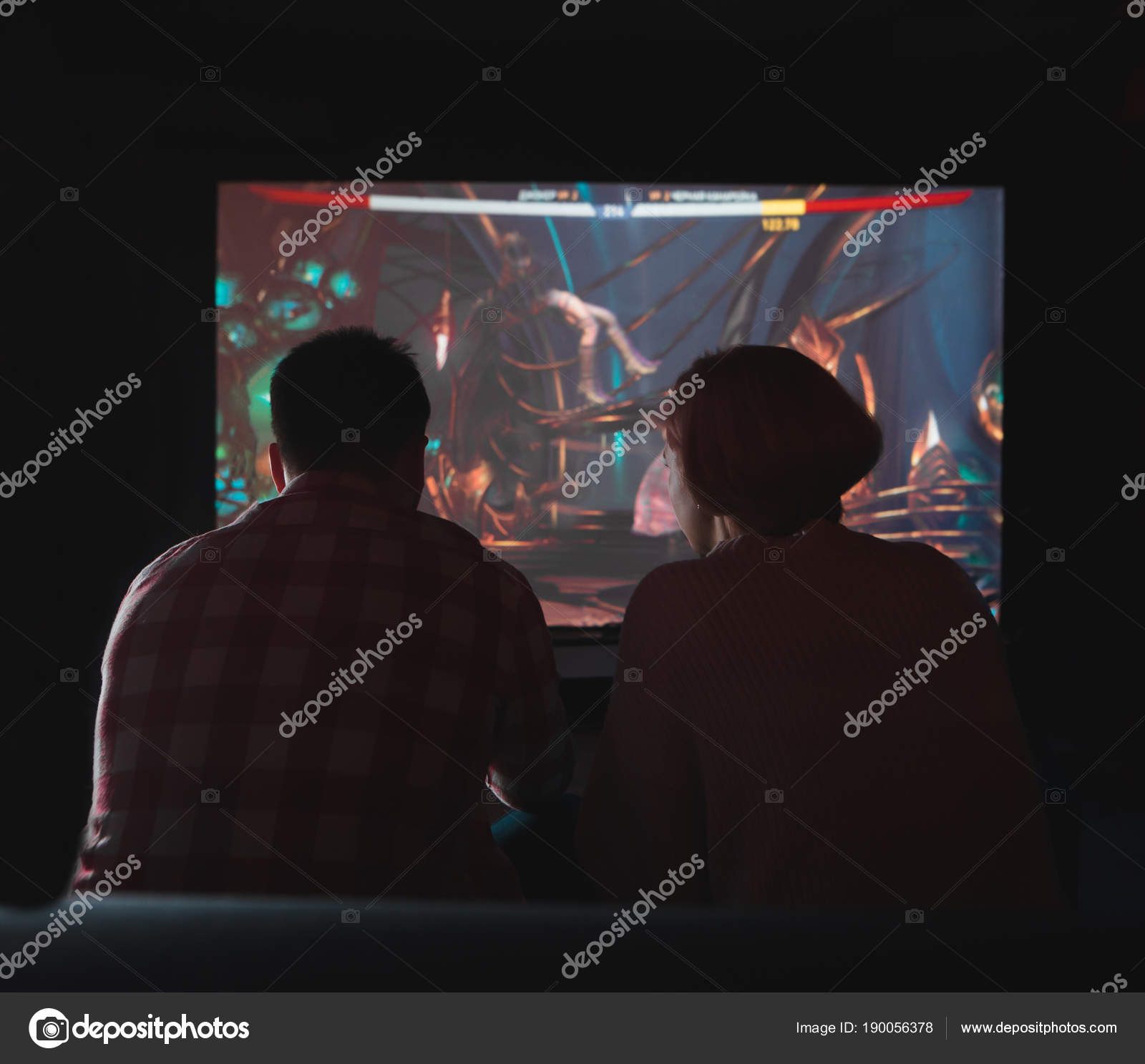 Um casal jogando videogames à noite em uma grande TV. Os jogadores se  sentam no sofá, image size:1600x1487