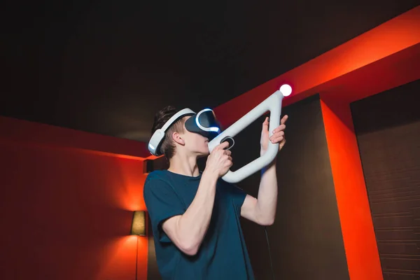 Gamer avec casque VR joue à des jeux de tir. Un jeune homme armé joue à des jeux de réalité virtuelle. Concept de réalité visuelle . — Photo