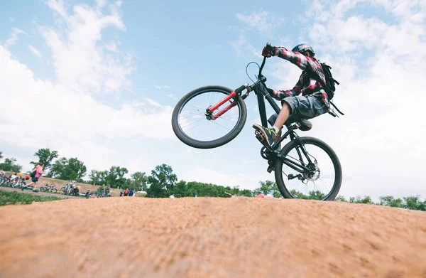 Ein junger Mann trickst auf einem Mountainbike. ein Radfahrer springt auf ein Fahrrad. — Stockfoto
