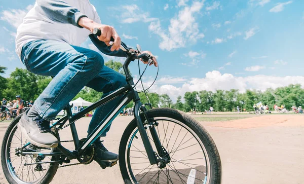 Hipster's husband rides a bike in sunny summer weather. Walking in the park on a bike. Close-up bike. Active leisure concept. — Stock Photo, Image