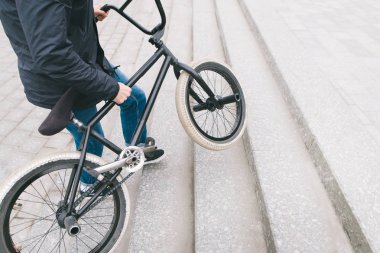 Bir insan ve Bmx yakın çekim bacaklar. Bisikletçi Bmx Bisiklet merdivenlerden yukarı yükseltir. Metin için yer