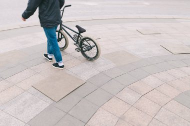 BMX kavramı. Bmx gelen bir genç cadde boyunca elini kolunu sallaya dönüyor. Boşaltmak