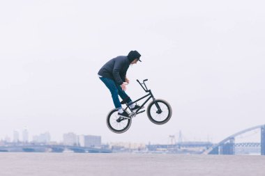 Genç Bmx okuyucu Barzpin hüner şehir manzarası arka planı yapar. BMX kavramı. Minimalist arka plan üzerinde hileler. BMX freestyle