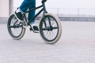 Genç Bmx Bisiklet okuyucu şehir etrafında üzerinde bir bisiklet ile gidiyor. BMX kavramı. Boşaltmak.