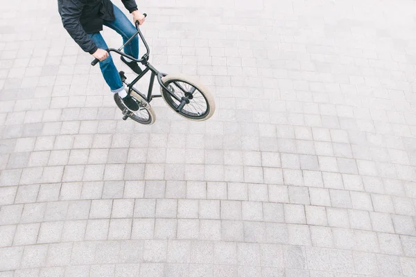 BMX freestyle op het plein bovenaanzicht. Een jonge man doet trucs op een Bmx fiets. BMX cultuur — Stockfoto