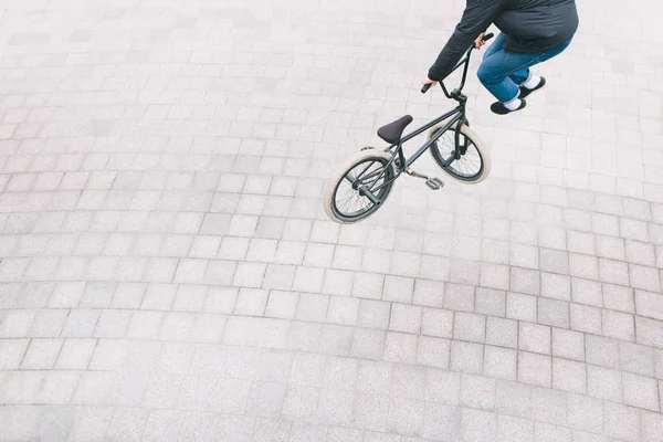 BMX racer maakt complexe trucs. Bovenaanzicht. De minimalistische foto van een fietser die trucs op een Bmx fiets doet. Straatcultuur weg te zinken — Stockfoto