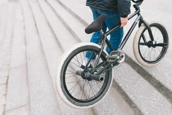 Een man roept de Bmx fiets op de trappen naar de top. Een man met een Bmx fiets. Copyspace. — Stockfoto