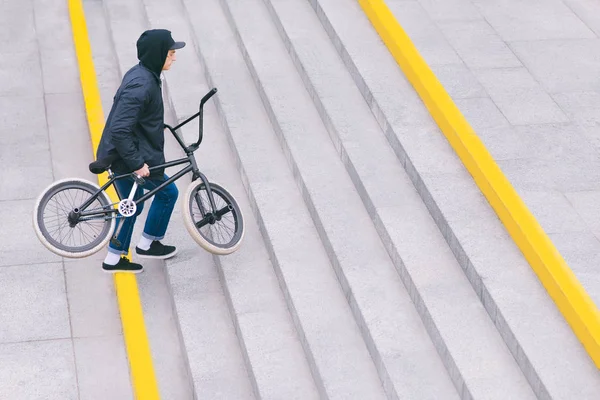 Walk around the city with BMX by bike. BMX concept. The man goes upstairs. Top view. Copyspace.