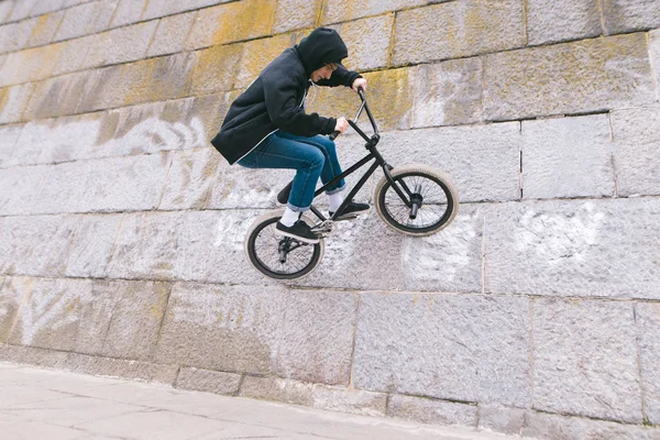 BMX rider biciklivel megy a falra. Egy fiatal férfi csinál Bmx. Bmx Freestyle trükkök — Stock Fotó