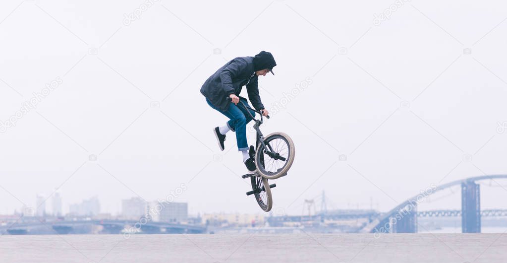 BMX rider makes a TAilwhip trick. Young man doing tricks in the air on a BMX bike. BMX freestyle