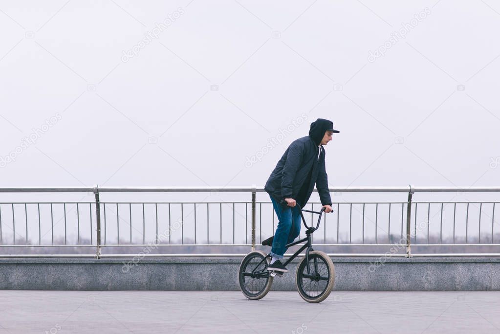 Portrait of a cyclist in casual clothing who rides on BMX. BMX concept. Walking on a bike