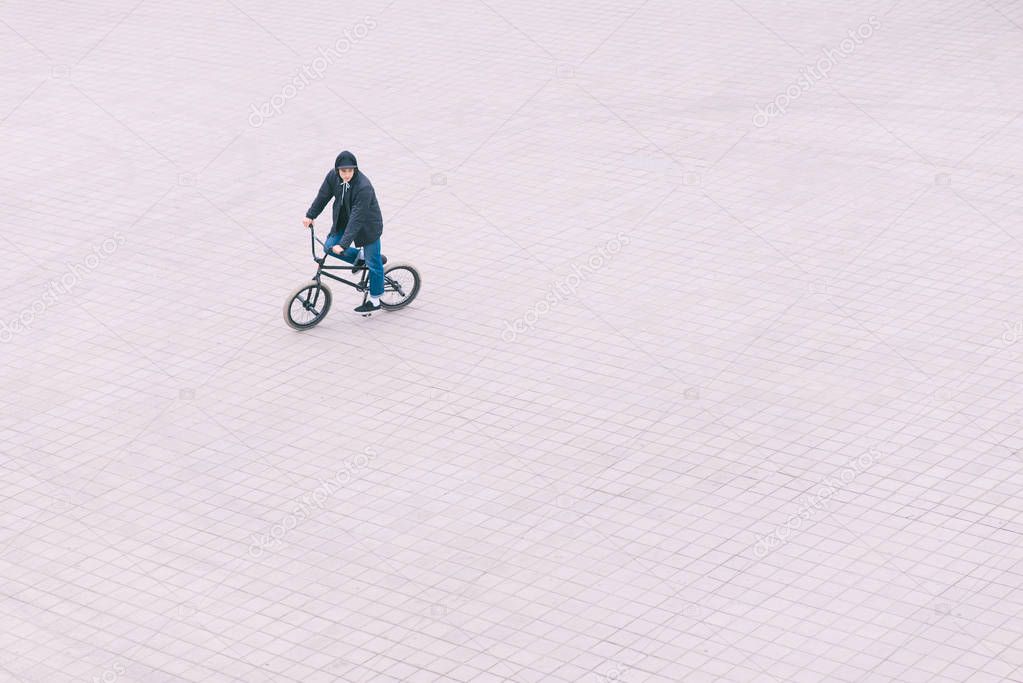 A man rides a BMX bike on a square, a view from above. BMX concept