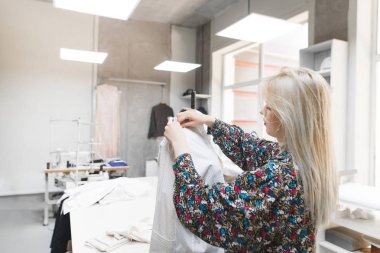 Terzi manken yakınındaki Studio'da anlamına gelir ve giysileri ayarlar. Moda giysiler oluşturulması. Terzi ve kukla giysileri ile. Dikiş kavramı