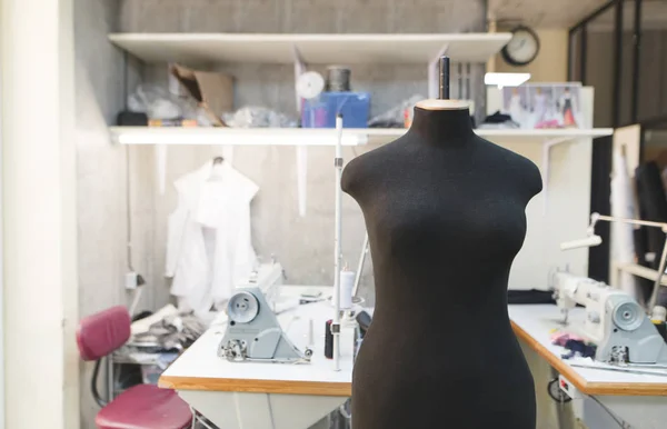 Maniquí negro de pie en un estudio de costura trabajos de fondo. Creación de ropa de moda. Concepto de costura . — Foto de Stock