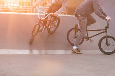 BMX biniciler bir skate Park arka plan günbatımı üzerinde hileler yapmak. Akşam eğitim Bmx bisiklet. BMX kavramı