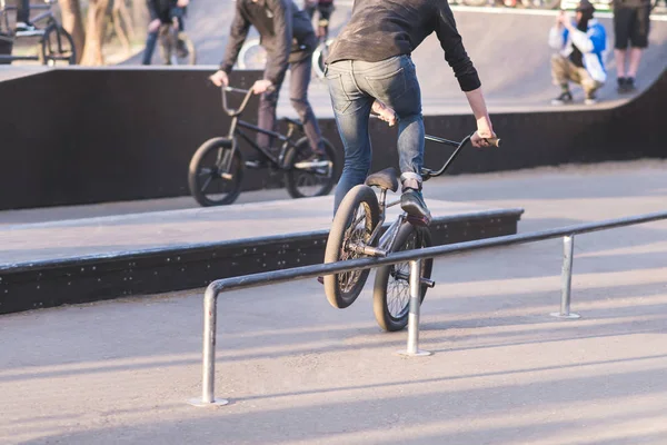 Δύο ποδηλάτες με ποδήλατα Bmx κάνει κόλπα σε ένα πάρκο skate. Ποδήλατο σκέιτερ διαφάνειες για Bmx από perel. Κατάρτιση κόλπα για Bmx — Φωτογραφία Αρχείου