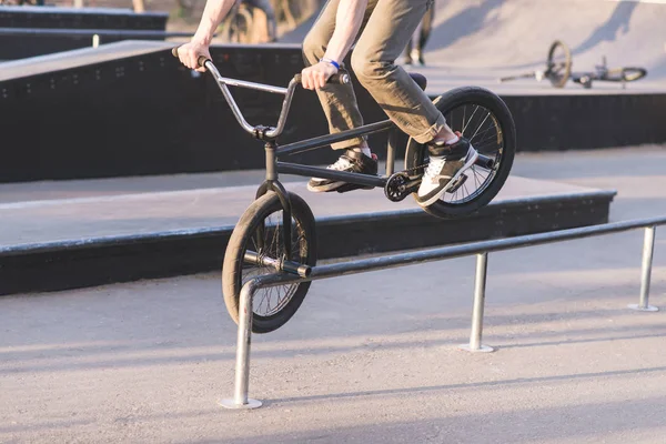 Αναβάτη BMX διαφάνειες κατά μήκος των σιδηροτροχιών στο μπροστινό τροχό. Ο έφηβος κάνει κόλπα με ποδήλατο bmx. BMX έννοια. — Φωτογραφία Αρχείου