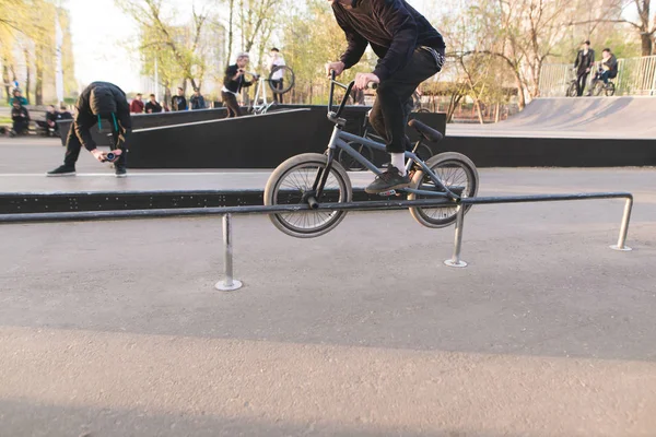 BMX bike racing in a park skate. BMX rider makes a trick on the handrail. The videographer removes as a rider slides on the railing. BMX tournament. — Stock Photo, Image