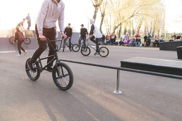 BMX fietsers rijden een fiets op een skatepark. BMX rider op de achtergrond van het park en de mensen met fietsen. BMX concept. — Stockfoto