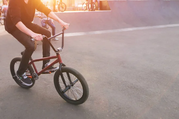 BMX rider jezdí skate park v pozadí západu slunce. Večerní trénink na Bmx. Bmx koncept. Copyspace — Stock fotografie