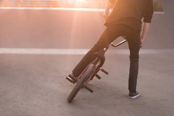 Bmx piloto executa truques em uma bicicleta bmx em um parque de skate no fundo do pôr do sol. Conceito Bmx. Espaço de cópia . — Fotografia de Stock