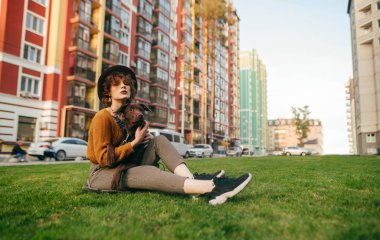 Kıvırcık saçlı ve köpekli güzel bir kızın portresi.